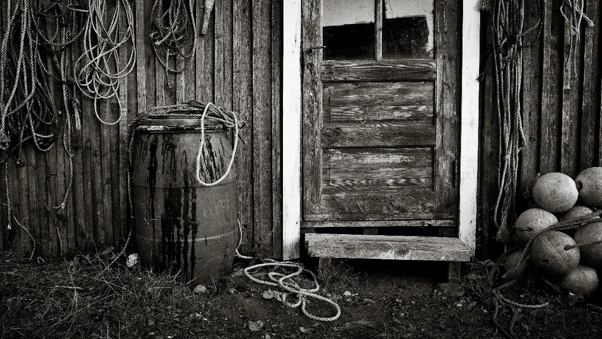 A view of a fisher's hut with barrels, ropes and nets in front of it