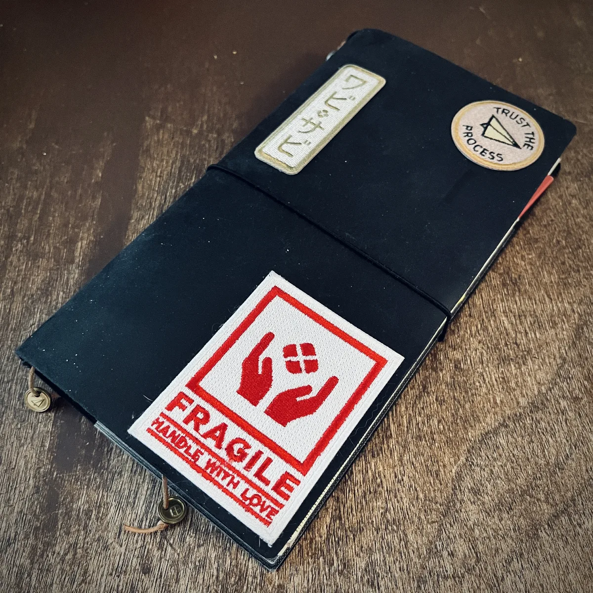My black Travelers Notebook with the all the patches on it