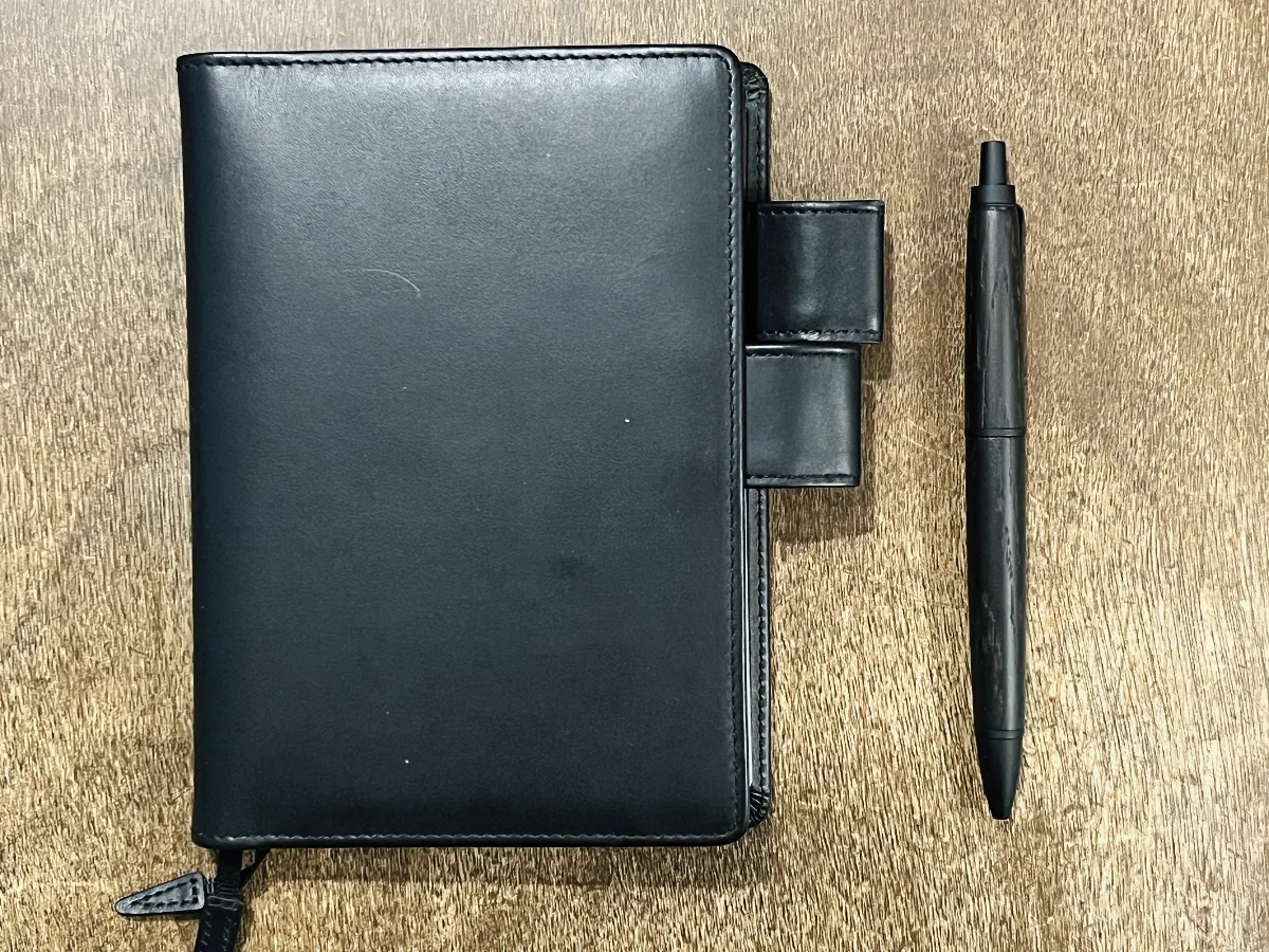 A picture of the pen next to my Hobonichi notebook