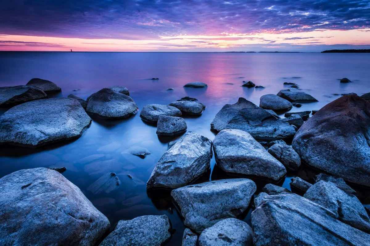 A picture of the sea at Rivinikka with rocks in the foreground and in front of a Sunset