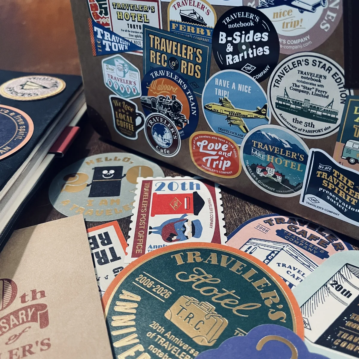 A picture of the Travelers Notebook 20th anniversary tin box with the stickers in front