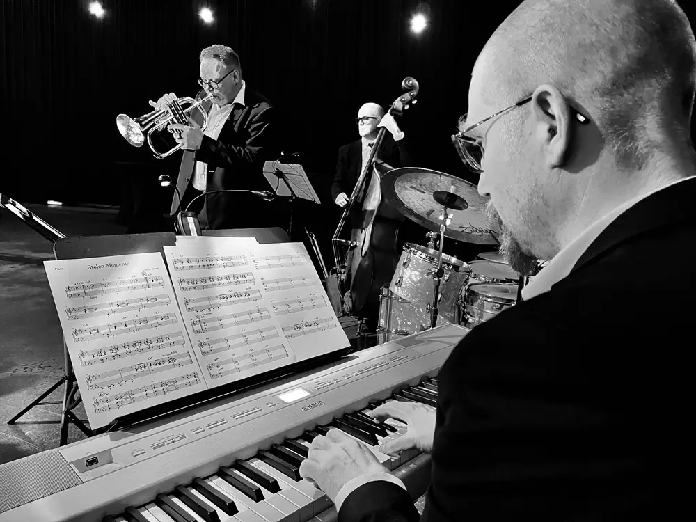 A picture of the band taken from behind the piano player